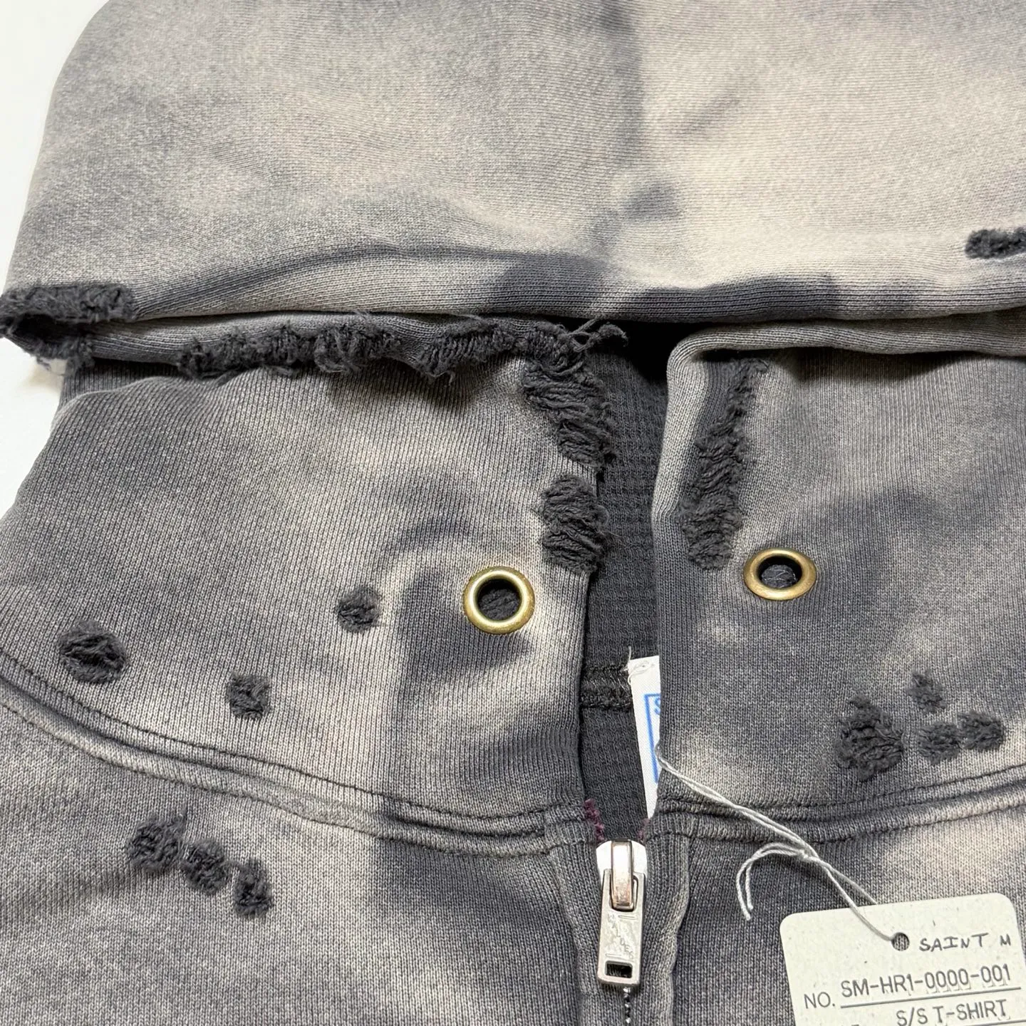 More details SAINT Mxxxxxx DBL FACE ZIP UP HOODIE/CHARCOAL Double-layer destroyed waffle zipper jacket, washed black S-XL, a style that has been used in the summer. After continuous fine polishing, it is finally shipped. The finished product is simply a work of art. Super heavy washing and distressing, multiple horse water fading, many hand-made wormhole destruction processing, deconstruction and reorganization embroidery technology, custom-made zipper with LOGO, and the color details of the zipper webbing are also correct. Original grade fruit main label and wash water label. Top purchasing grade. A layer of waffle fabric is added to the inner lining to make the overall texture stronger and increase the comfort and warmth of the wearer.